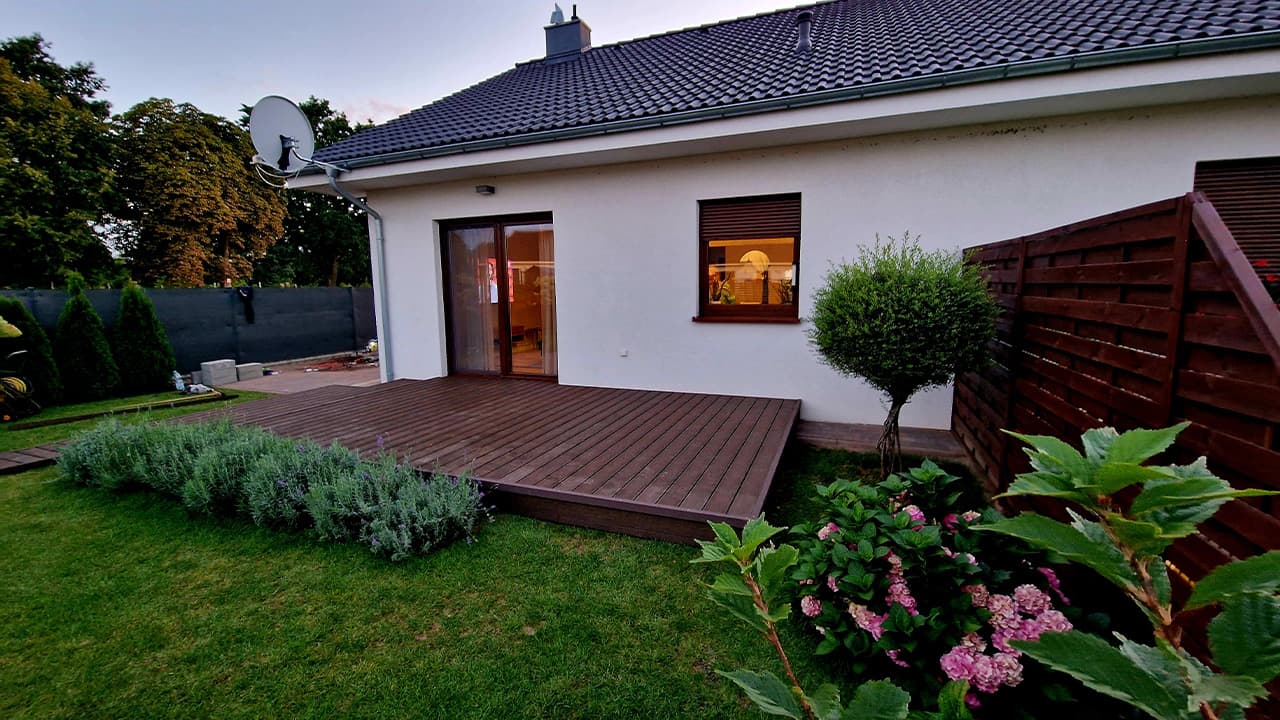 Brown decking beside a building, surrounded by greenery — a Garden Polska project in Zielona Góra