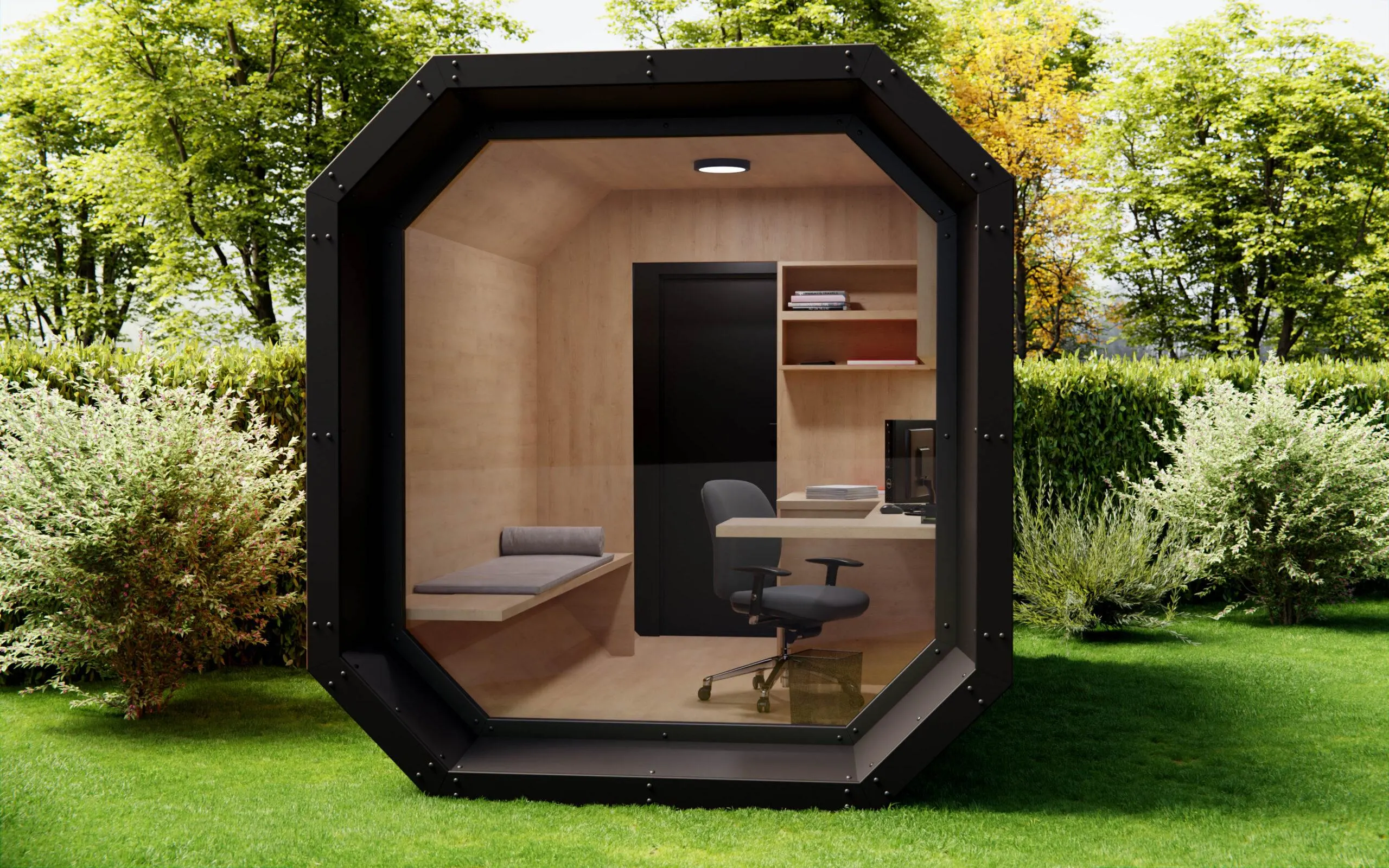 Octagonal garden office with a glazed front, furnished with a desk and chair, standing on a green lawn.