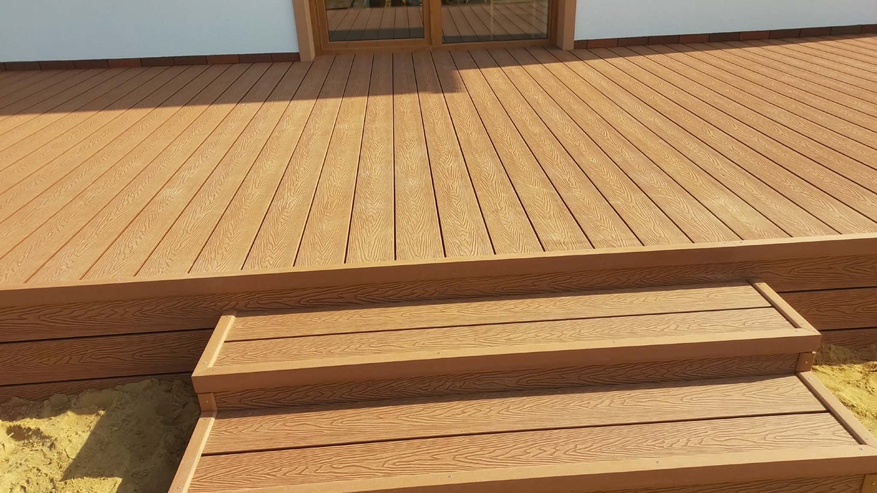 Terrace and steps made from copper-coloured Duo composite decking boards with a woodgrain finish.