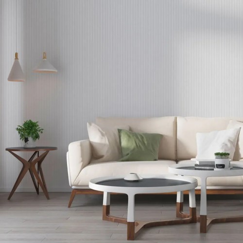 White fluted panel on the wall of a bright living room with a cream sofa and wooden coffee tables.