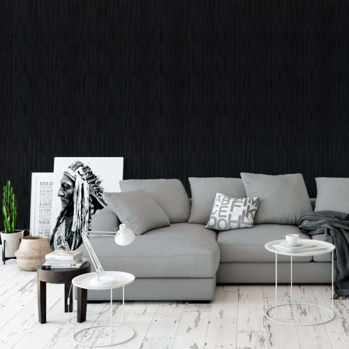 Black acoustic panel on the wall of a modern living room with a grey sofa and white tables.