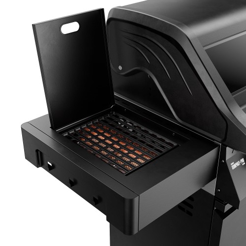 Open FLAME ZONE side burner cover, with the zone glowing beneath the grates in a black gas grill.